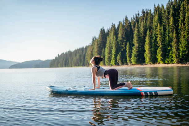 istock Tranquil scene of woman doing yoga on paddleboard. 1452788809