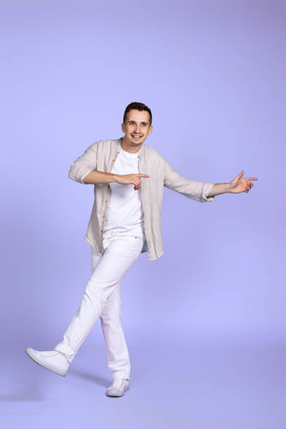 istock happy man walks isolated on violet background. 1452789090