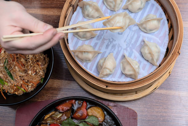 Delicious asian dumplings in bamboo steamer on wooden background. Selective focus. Asian food concept