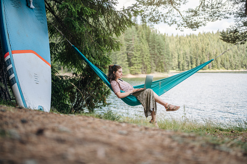 Young woman on camping working remotely.Balancing between work and vacation.