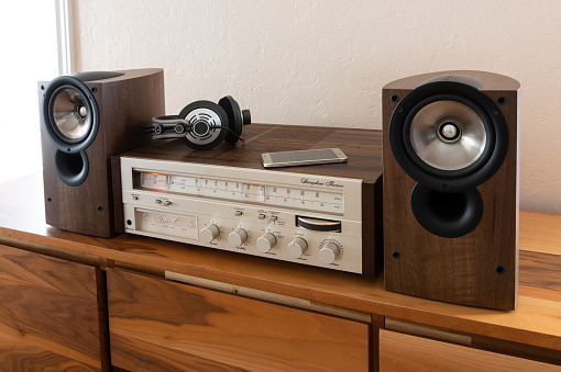 A frontal shot of a retro style FM/AM radio against a white light background.