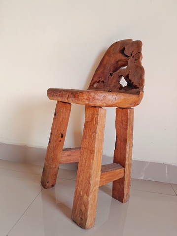 An antique wooden chair put in front of the wall