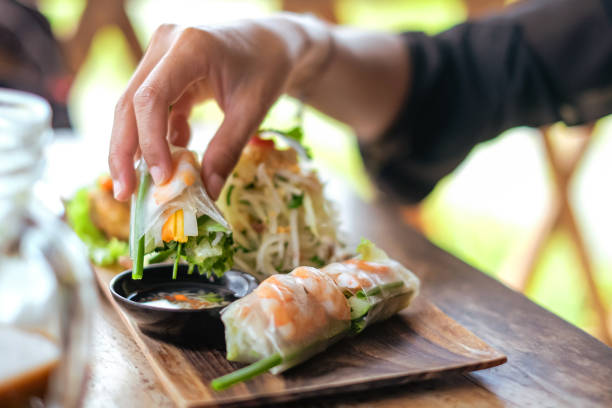istock Unrecognizable Women Dipping a Vietnamese Shrimp Spring Rolls Into the Sauce 1452798188