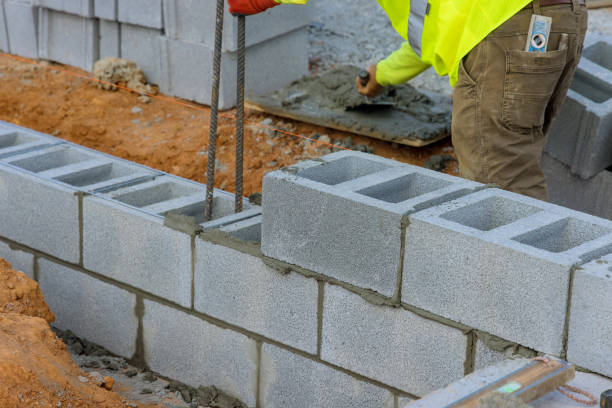 istock The bricklayer construction worker is laying down another row of cement blocks in the construction site 1452807695