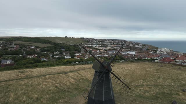 Aerial flies to sails of antique Beacon Mill windmill in southern UK