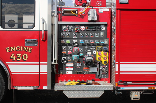 Belmont, NC, USA-November 23, 2022: Closeup of hose connection and control panel on the side of stationary fire engine