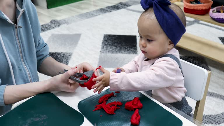 Mother teaching toddler to make shapes with Play-Doh