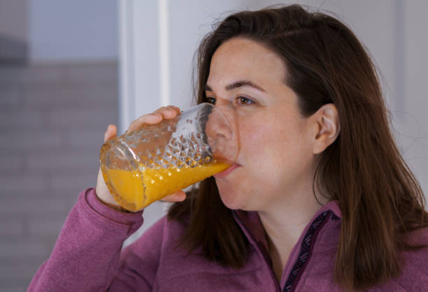 istock young girl in profile drinking freshly squeezed orange juice 1452821997