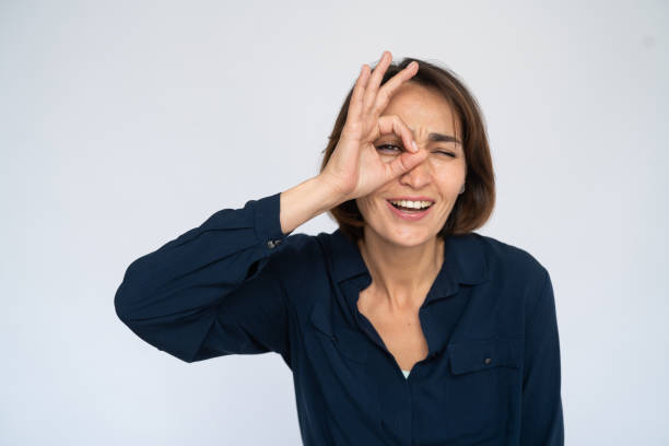 istock Confused woman looking through okay gesture 1452828086