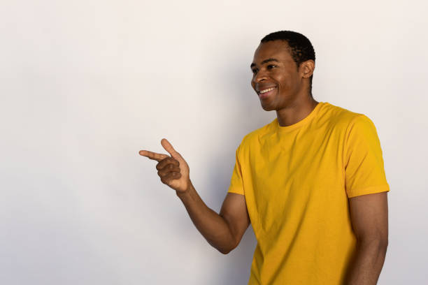 istock Portrait of happy young man pointing aside 1452829468