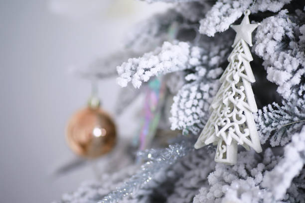 istock Christmas holiday background. Silver and color bauble hanging from a decorated on tree with bokeh and snow, copy space. 1452831264