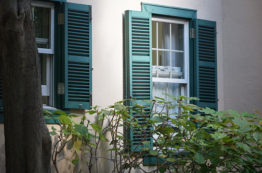 Window with shutters in Ponta Delgada which is the main city on the Portuguese Azorean island San Miguel in the center of the North Atlantic Ocean. The narrow streets and low houses make this kind of closing quite common