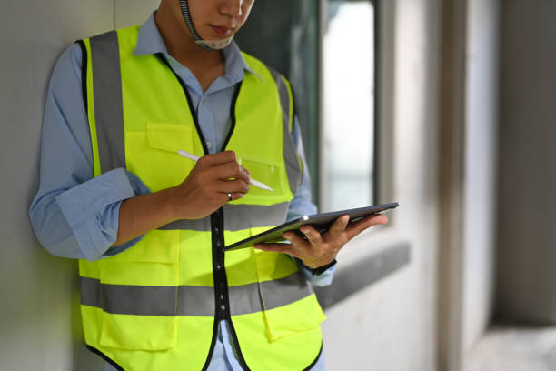 istock Cropped shot of engineer man in reflective jackets using digital tablet, inspecting building construction site. 1452832734