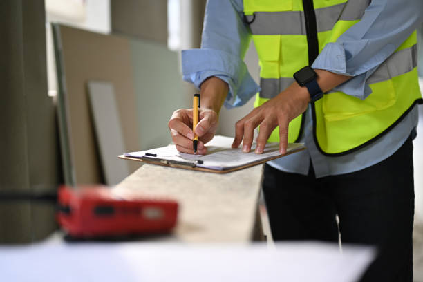 istock Engineer in reflective vest standing in construction site and checking building construction progress. 1452833269
