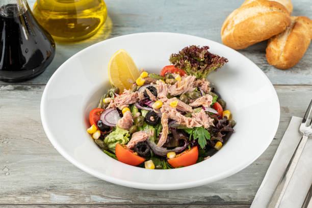 салат из тунца в белой фарфоровой миске. концепция здорового питания - sandwich tuna tuna salad sandwich salad стоковые фото и изображения