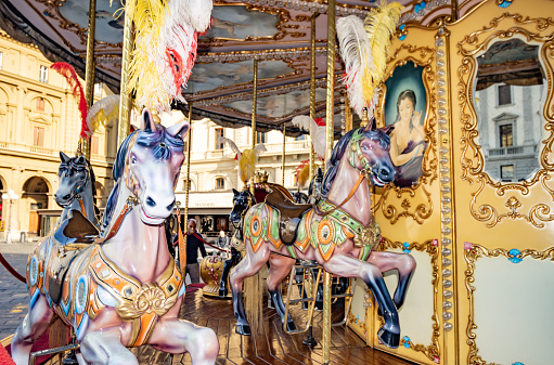Carousel Horses on Piazza della Repubblica in Florence at Tuscany, Italy. Copyrighted patterns are visible on the horses.