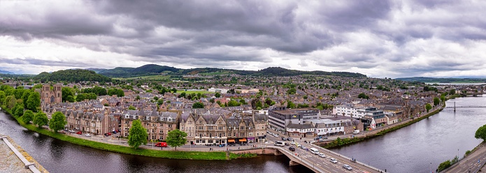 A panorama shot of Inverness city along River Ness under cloudy sky