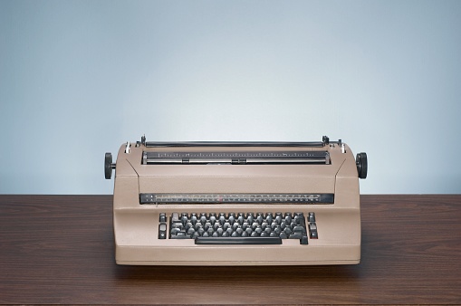 A closeup of a vintage typewriter on a wooden table