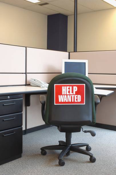 istock Vertical shot of a working place interior with a Help Wanted warning on the chair 1452839100