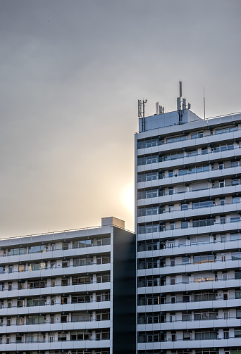 Roermond, Netherlands – March 31, 2022: A vertical beautiful shot of two high Appartement buildings with a sunset behind in Roermond, Netherlands