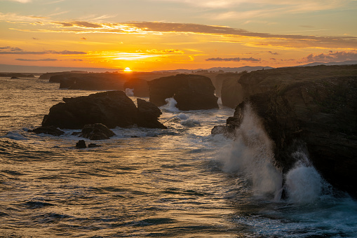 Playa de las Catedrales: enormes olas del océano rompiendo sobre acantilados rocosos al amanecer photo