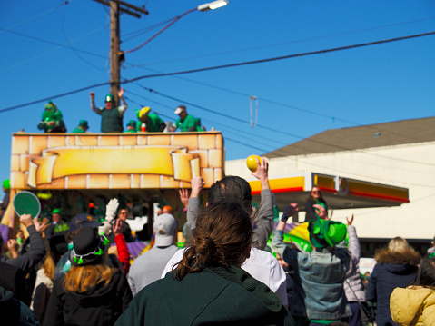 New Orleans, United States – March 12, 2022: A crowd watches floats in the Irish Channel St. Patrick's Day Parade in New Orleans, United States