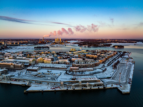 Helsinki, Finland – December 24, 2021: Aerial view of sunlit Katajanokka cityscape, winter sunset in Helsinki - tracking, drone shot