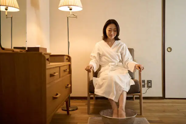 Asian woman getting warmed by footbath at beauty salon