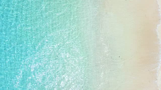 Tropical beach with turquoise ocean water and waves, aerial view. Top view of paradise beach in tropics