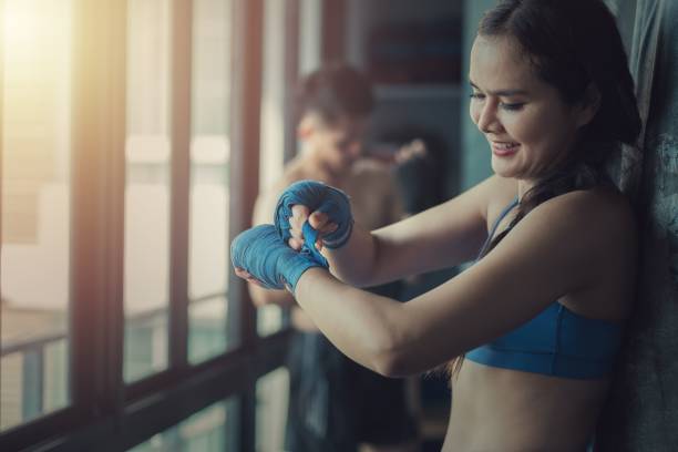 istock Young female boxer wearing a strap on her wrist in the gym 1452846111