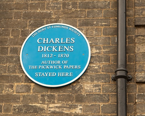 Bury St Edmunds, United Kingdom – July 22, 2020: Historic blue plaque showing English novelist, Charles Dickens stayed here on wall of building