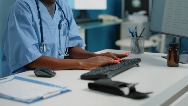 istock Close up of medical assistant typing on computer keyboard 1452847317