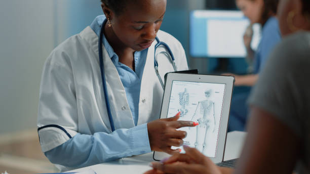 istock Woman working as doctor holding tablet with skeleton image 1452847477