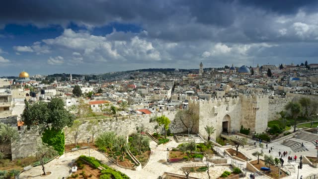 Time lapse of Damascus Gate and old Jerusalem City. People walk in the park entering the old city of Jerusalem through the Damascus Gate
