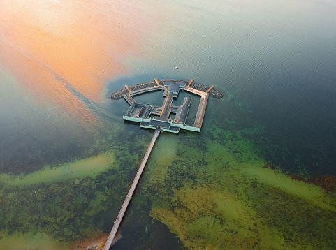 An aerial shot of the Ribersborgs Kallbadhus open-air bath in the middle of the water in Malmo, Sweden