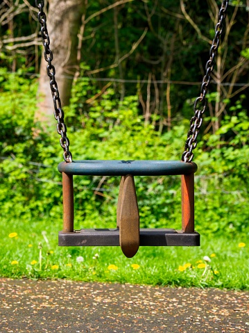children's swing in the public park on a sunny summers day nobody