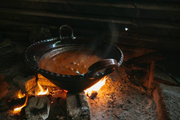 istock Mexican indigenous woman preparing Mole on a clay pot 1452848419
