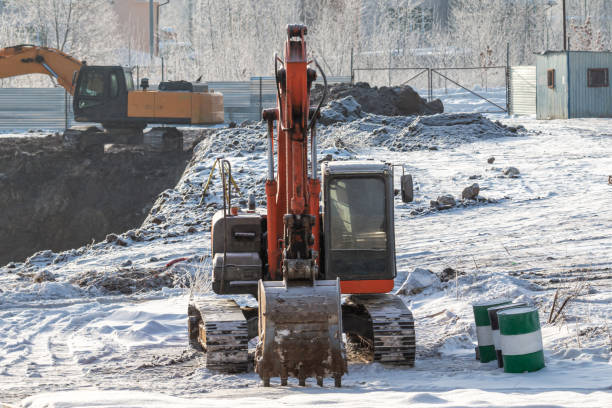 istock Orange and yellow crawler excavators at a construction site in winter 1452849563