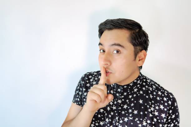 istock Young man asking to keep quiet with his finger 1452850671