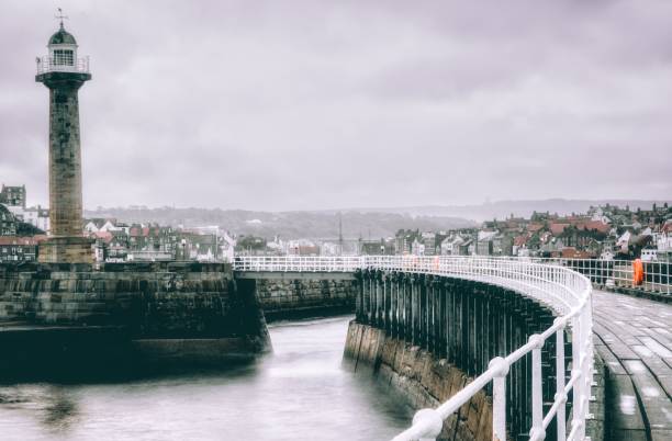 The iconic light house and curved bordwalk of Whitby pier on a cold winters morning.