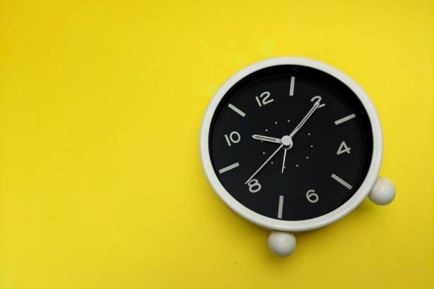 istock Top view of an alarm clock isolated on yellow background 1452853583