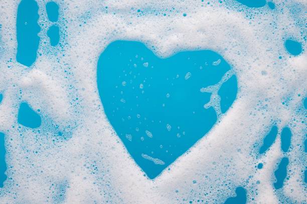 istock Heart-shaped foam over blue water with copy space. 1452853905