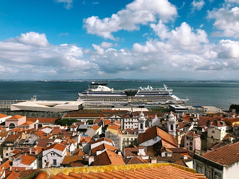 Lissabon, Portugal – April 09, 2019: A stunning shot of AIDAdiva cruise ship and beautiful buildings with red rooftops in Lisbon, Portugal