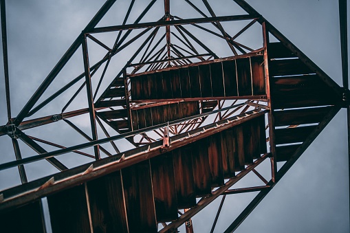 A low angle shot of fire tower stairs against the blue sky