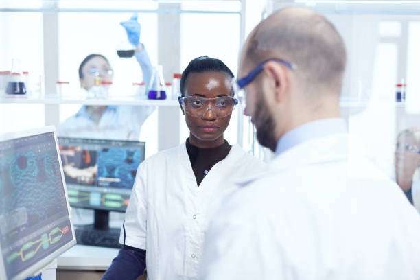 istock Serious african medical scientist discussing about virus experiment 1452858890