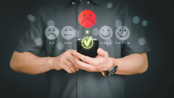 Photo of Unhappy man customer with sad emotion face on a mobile phone. Bad review and service dislike poor quality, low rating, bad social media not good. Customer experience dissatisfied and testimonial.