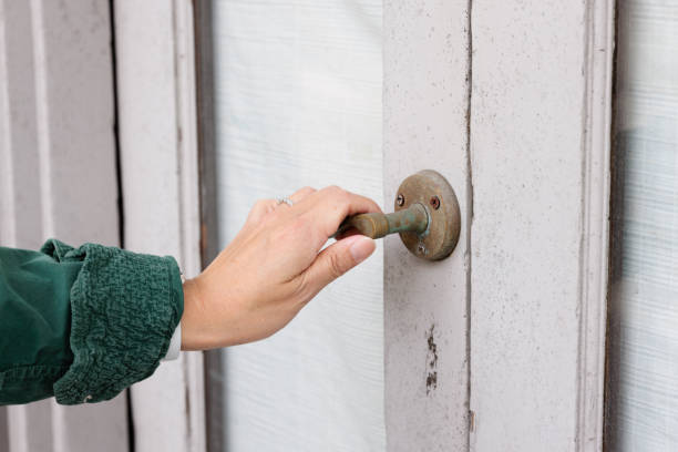 A woman's hand on a metal door handle.