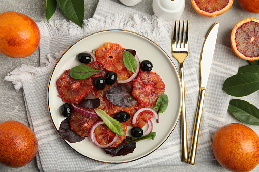 Delicious sicilian orange salad served on grey table, flat lay