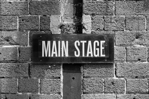 Old black metal sign showing the location of the main stage.