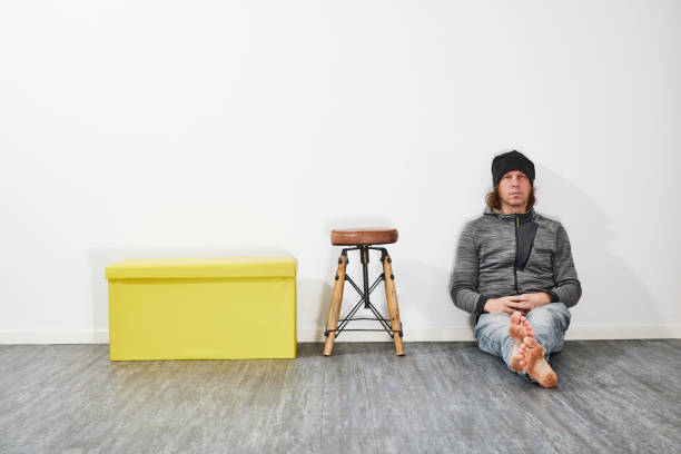 istock Man sitting on the floor beside a chair 1452865312